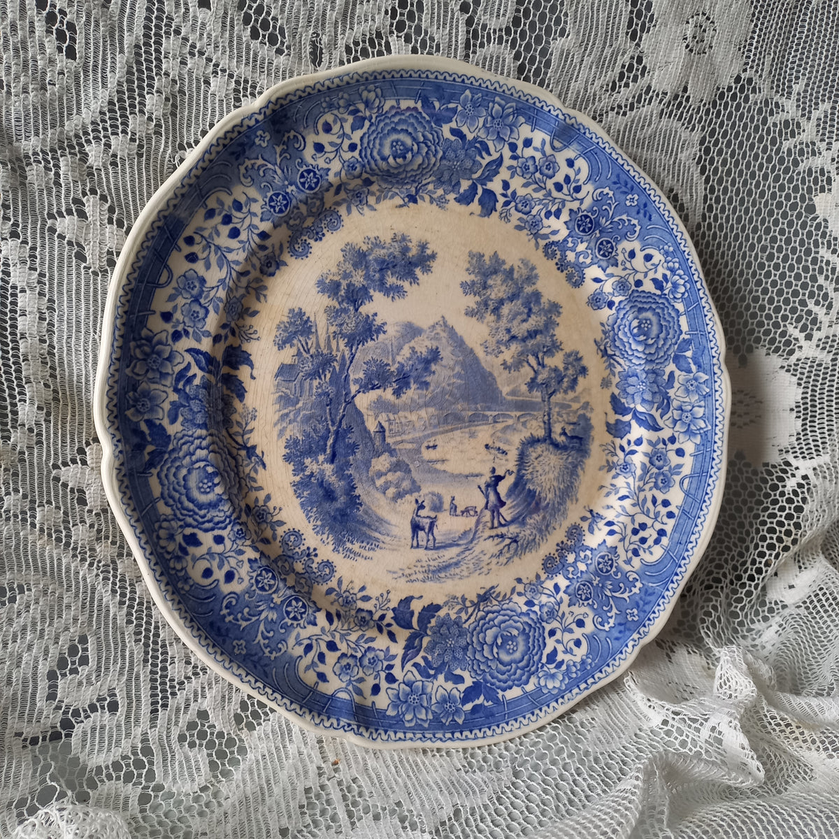 Blue and white decorative plate on a lace tablecloth