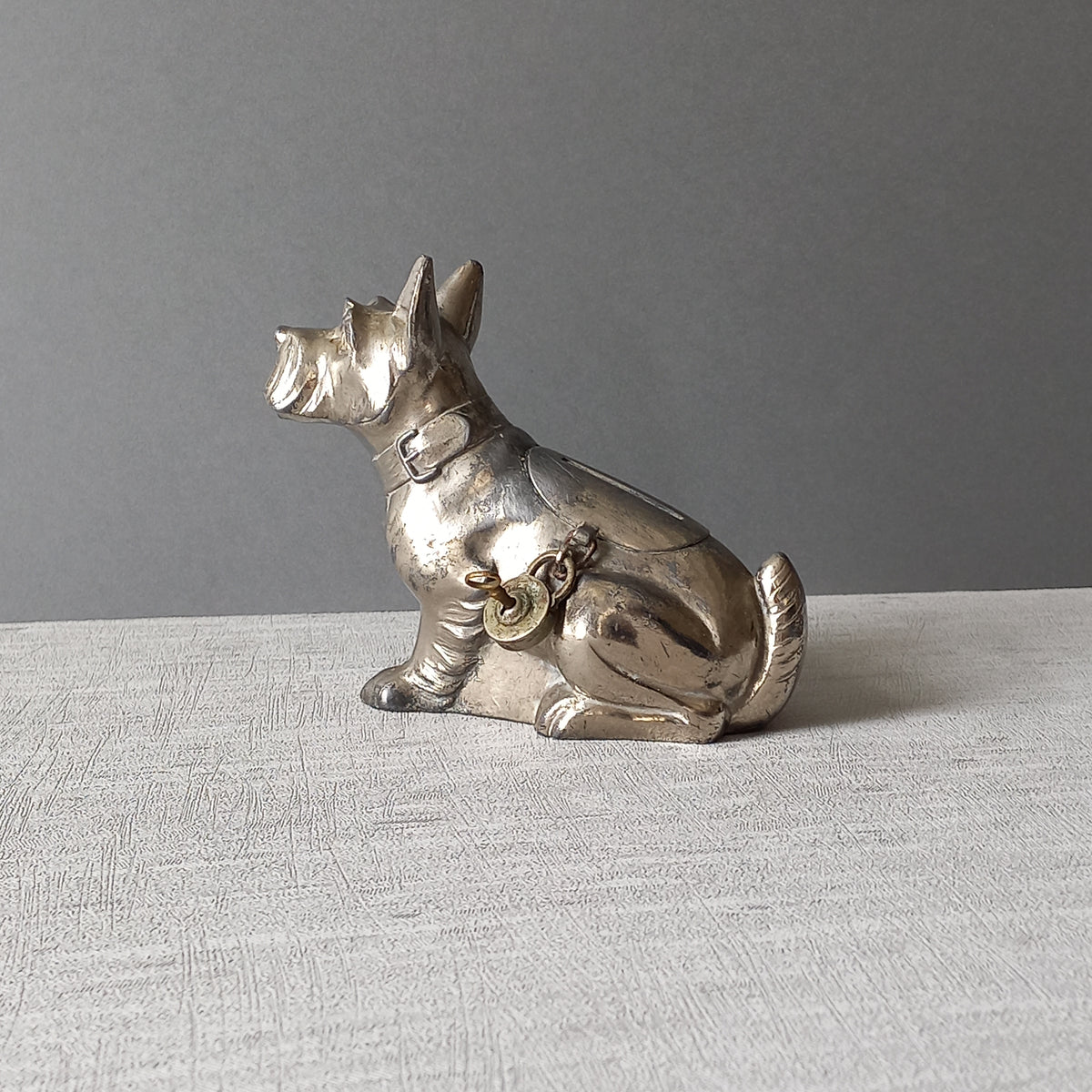 A fabulous French art deco metal terrier dog money box/coin storage box complete with a little padlock and key which still work. 

This unique piece of history was purchased in south west France and we can only imagine who once owned it and what they might have saved their coins to buy.