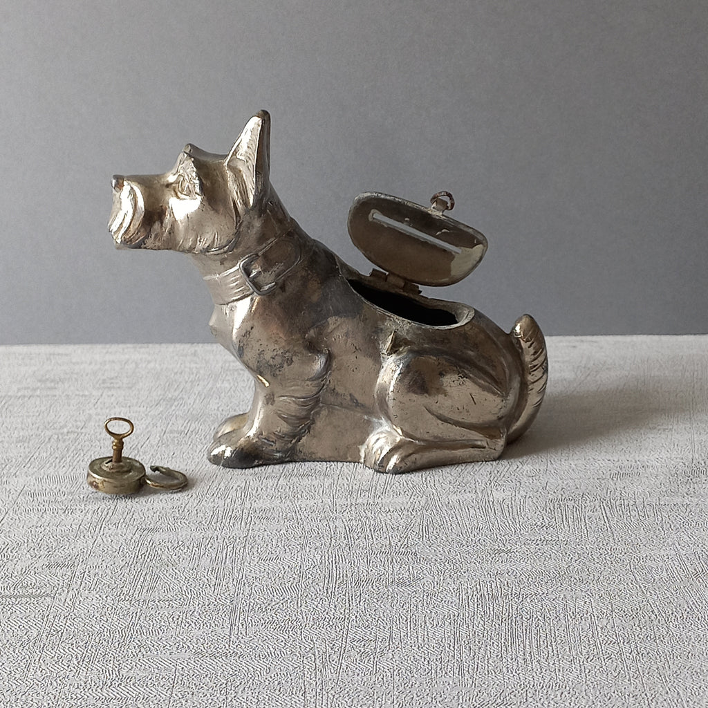 A fabulous French art deco metal terrier dog money box/coin storage box complete with a little padlock and key which still work. 

This unique piece of history was purchased in south west France and we can only imagine who once owned it and what they might have saved their coins to buy.
