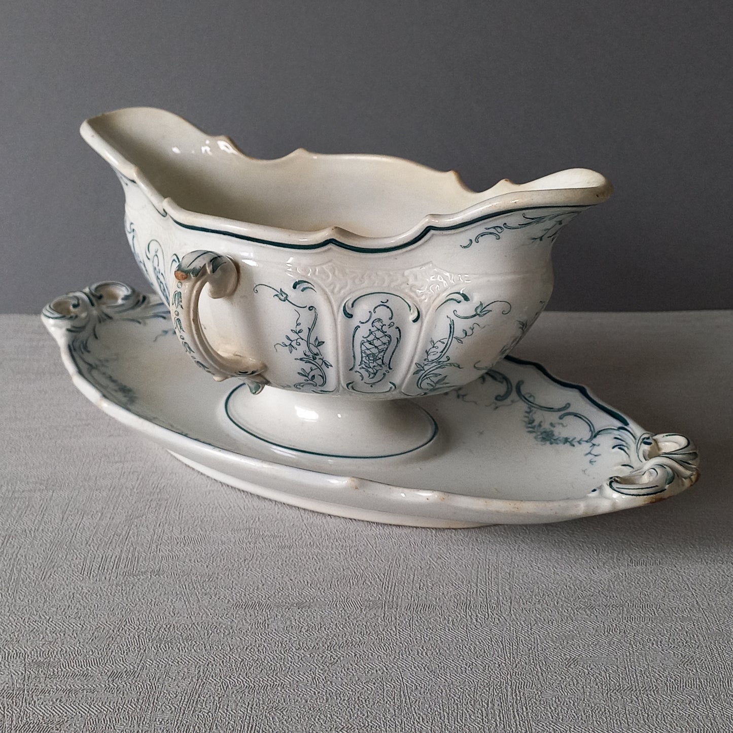 Large vintage ironstone sauce boat with a teal (blue/green) floral pattern.

This is a grand-looking and heavy piece, possibly manufactured by Villeroy Boch.

It's been well used and has the expected age-related wear - these days it's more suitable for home decor such as a herb planter and many other interesting uses.