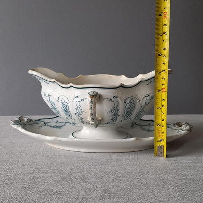 Large vintage ironstone sauce boat with a teal (blue/green) floral pattern.

This is a grand-looking and heavy piece, possibly manufactured by Villeroy Boch.

It's been well used and has the expected age-related wear - these days it's more suitable for home decor such as a herb planter and many other interesting uses.