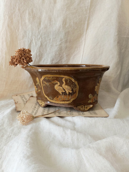 A stunning decorative glazed stoneware planter with oriental animal and floral design influences. 