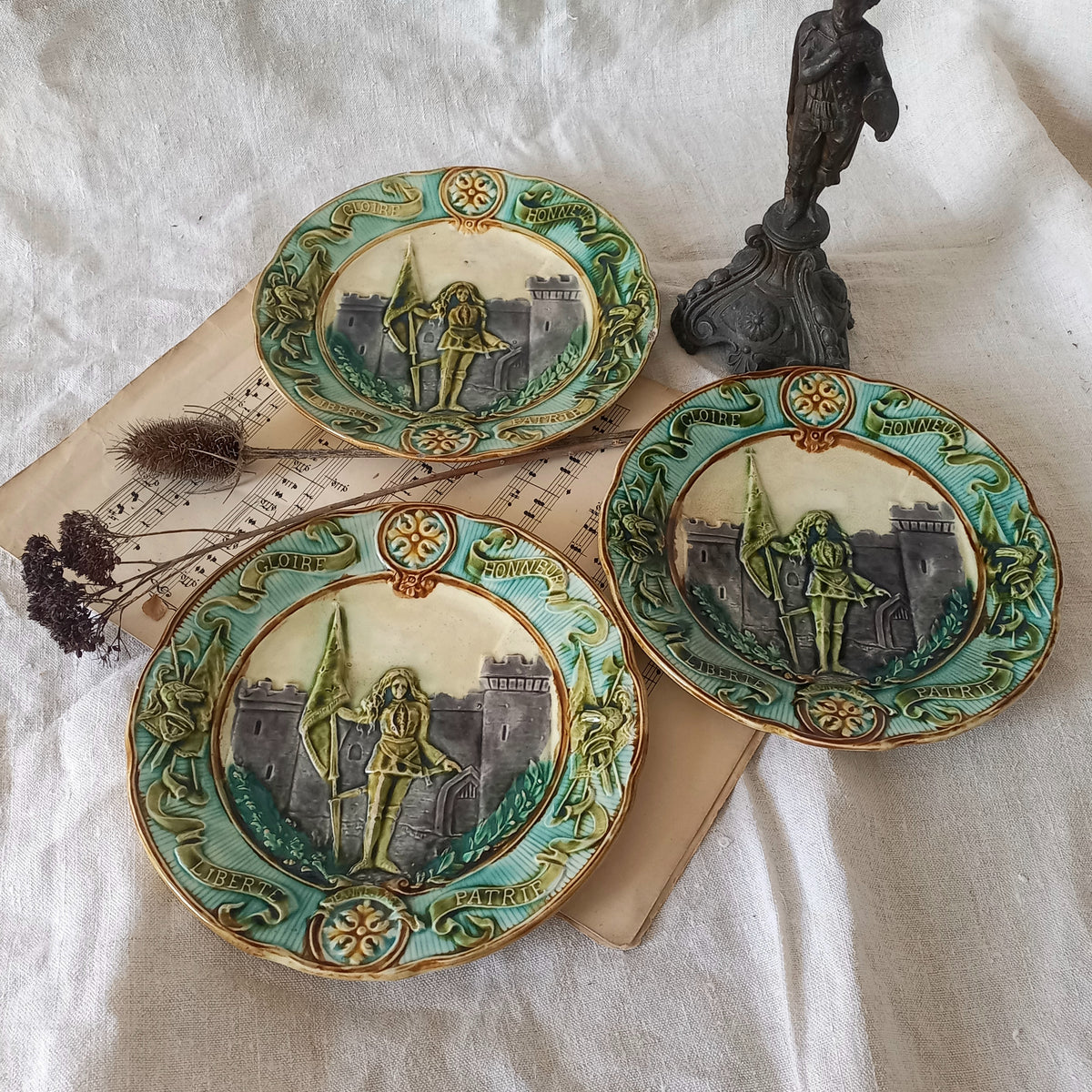 Three decorative plates with artistic designs on a textured surface