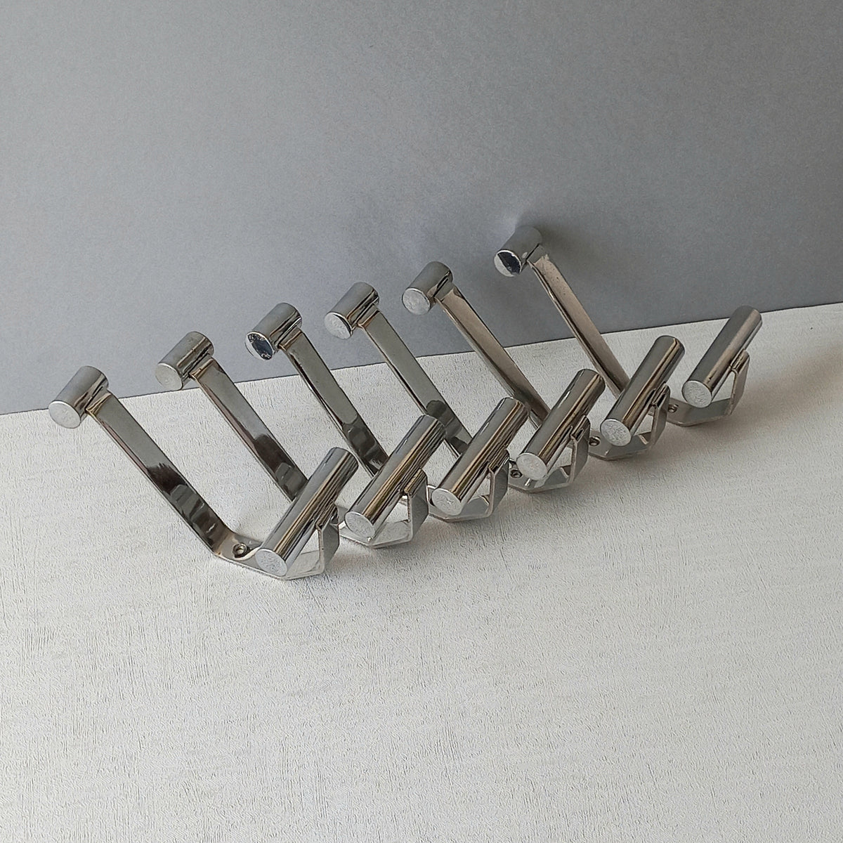 Set of 6 French vintage mid-century coat and hat hooks made from polished metal that can be simply fitted to your wall using the mounting holes.