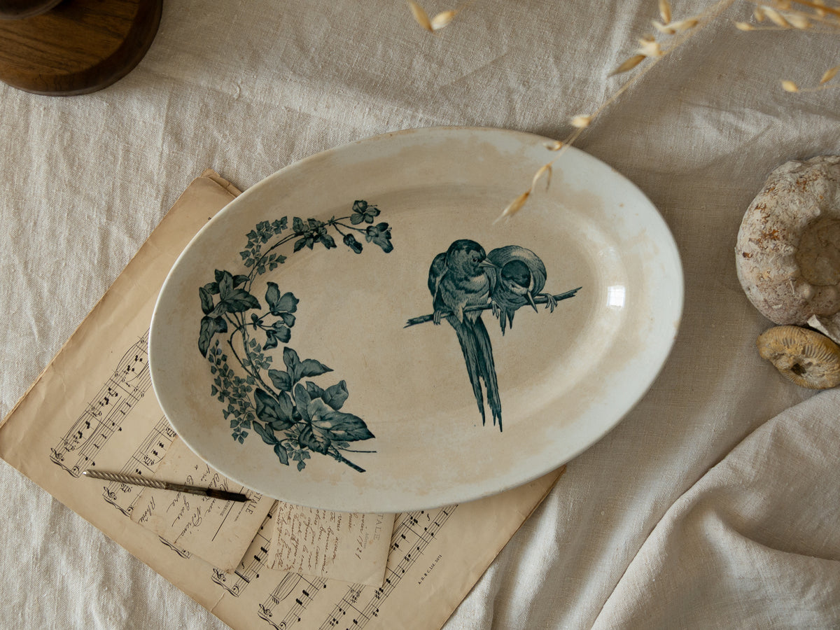 An absolutely stunning large French antique oval ironstone serving plate in a delightful time-worn creamy white with blue transferware pattern depicting two cute birds and flowers. 
