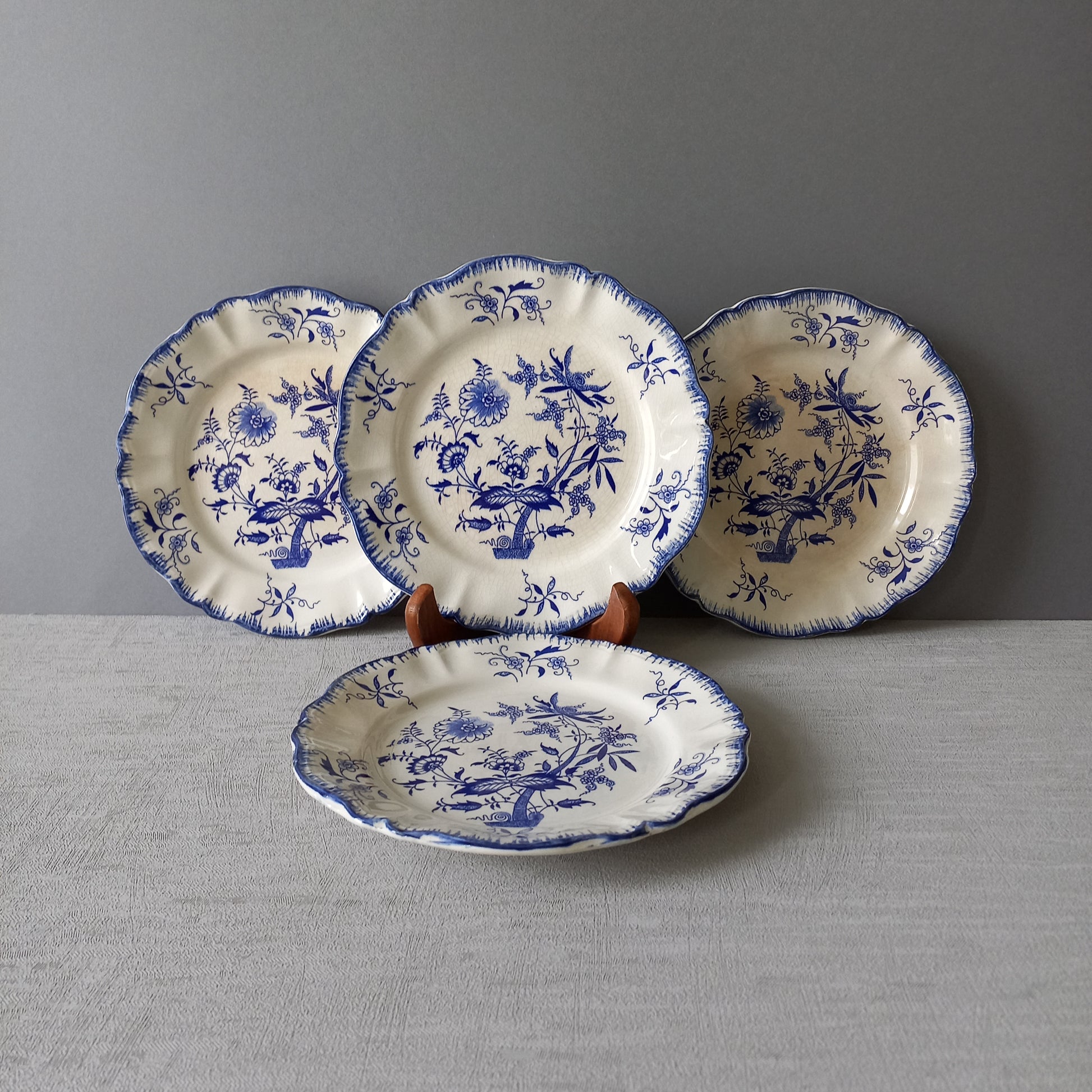 A stunning set of 4 small antique white ironstone plates with blue floral patterns from France.