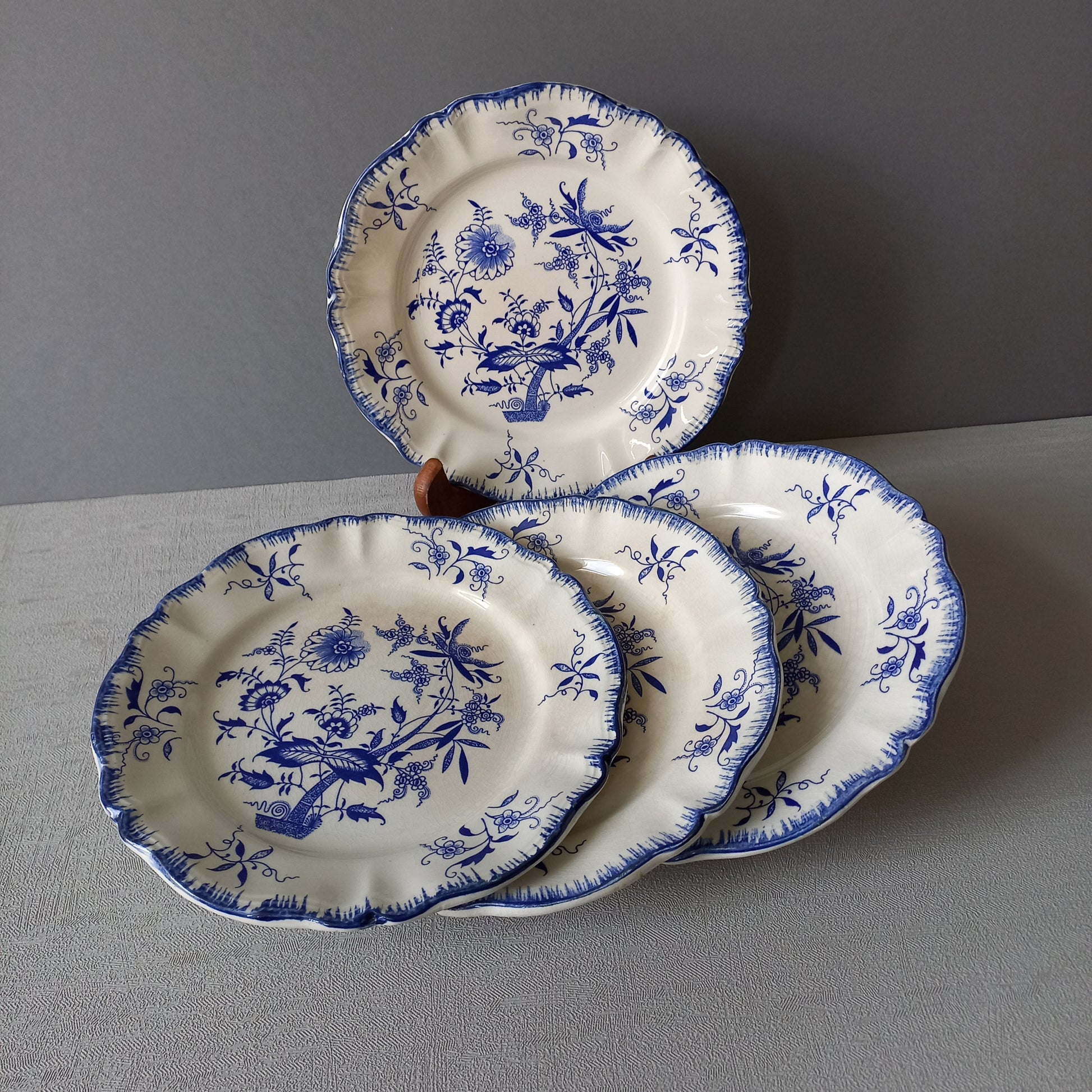 A stunning set of 4 small antique white ironstone plates with blue floral patterns from France.