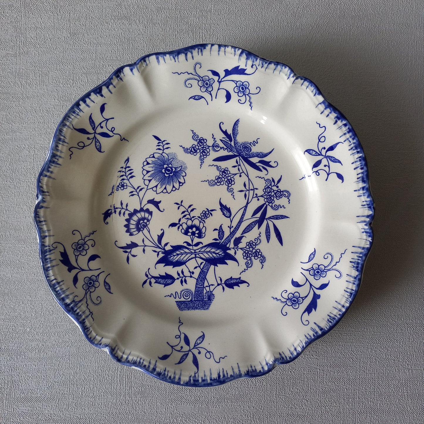 A stunning set of 4 small antique white ironstone plates with blue floral patterns from France.