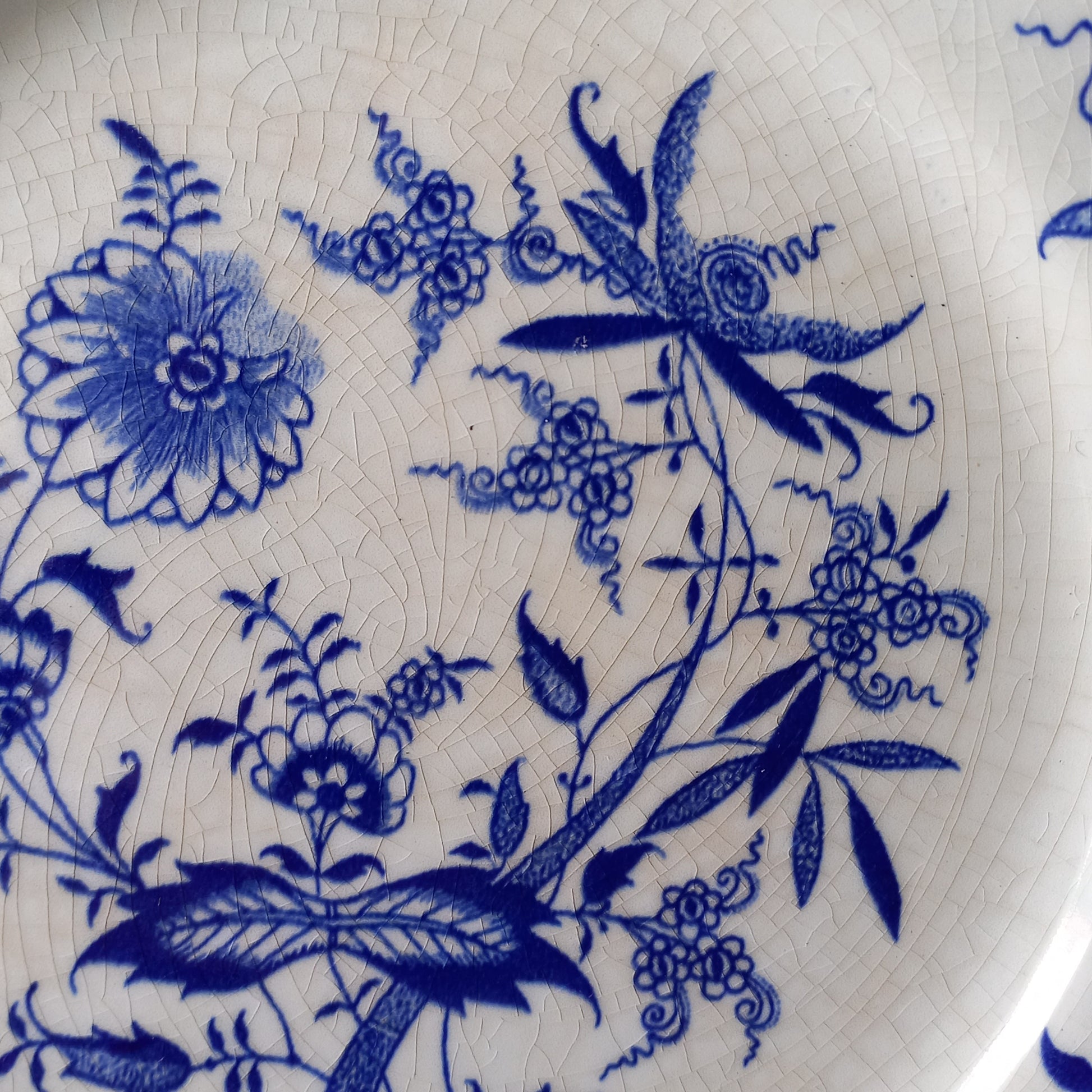 A stunning set of 4 small antique white ironstone plates with blue floral patterns from France.