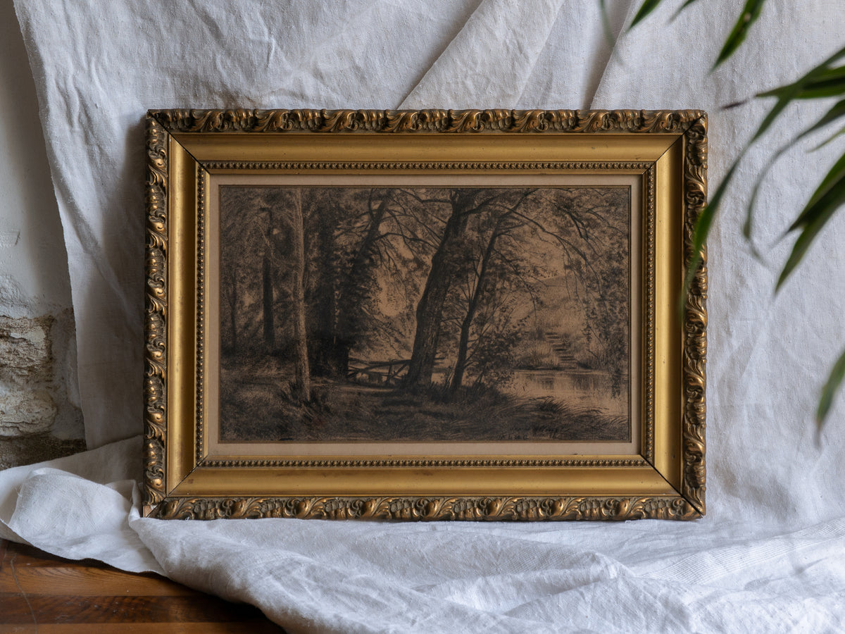 Framed artwork of a landscape with trees on a white fabric background