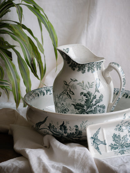 A French antique ironstone jug, basin and soap dish, printed in a soft teal-green bird-and-floral pattern. 