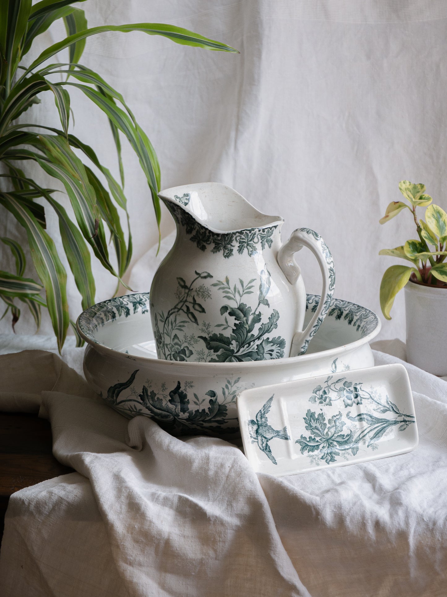 A French antique ironstone jug, basin and soap dish, printed in a soft teal-green bird-and-floral pattern. 
