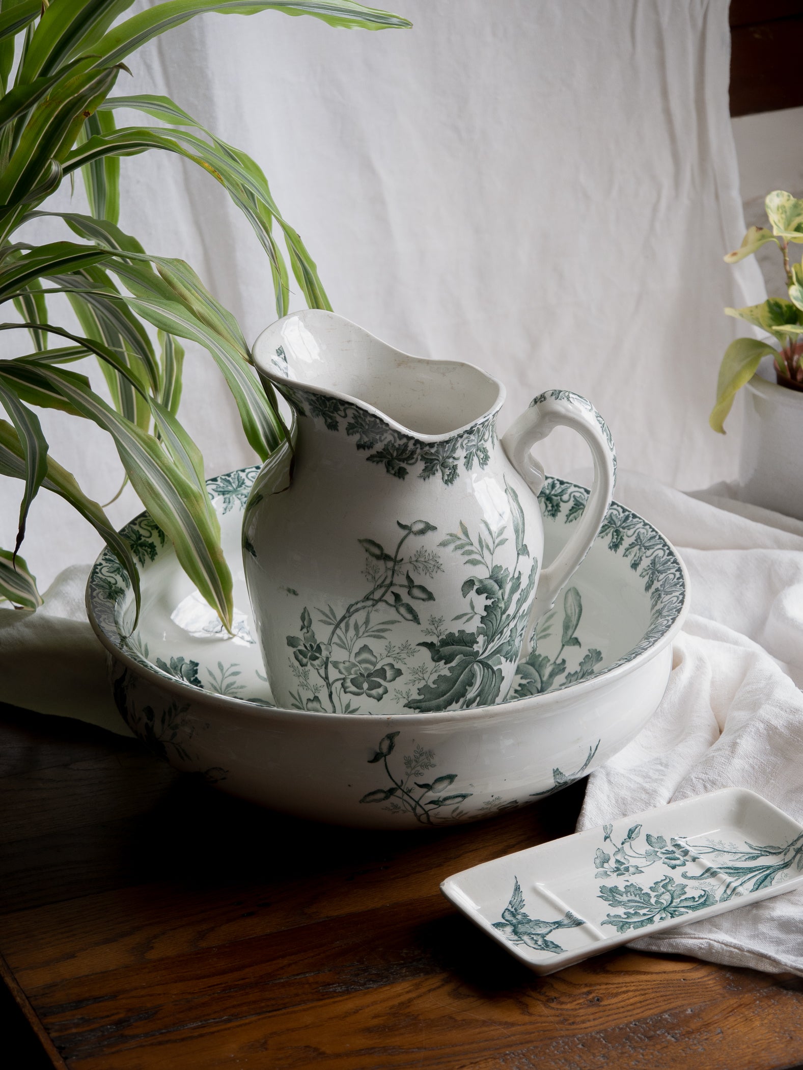 A French antique ironstone jug, basin and soap dish, printed in a soft teal-green bird-and-floral pattern. 
