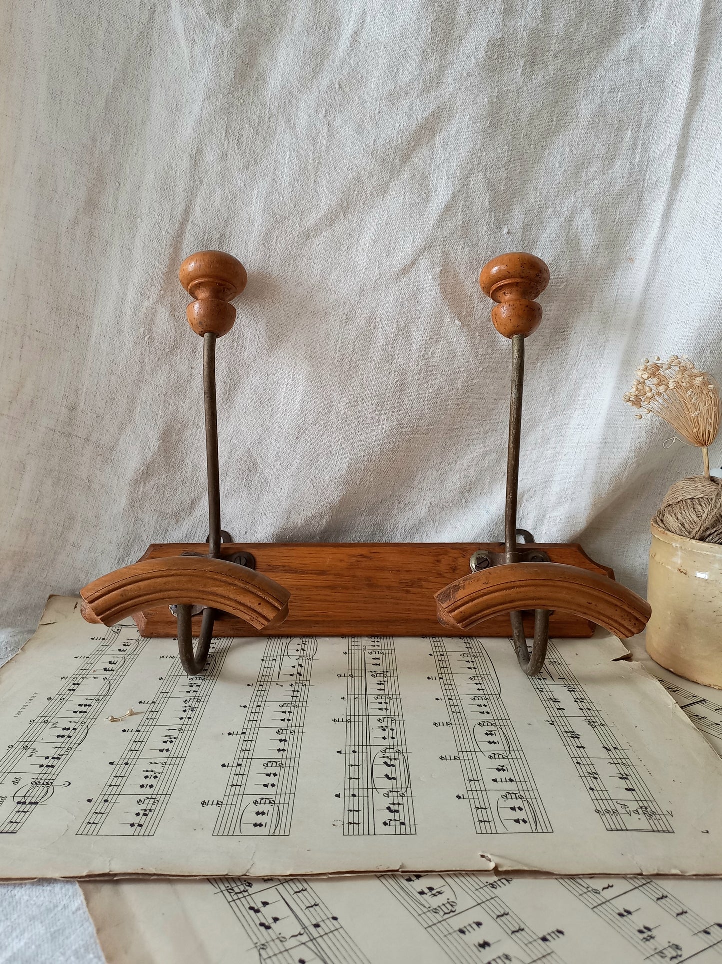 French vintage coat and hat rack with 2 metal hooks, each hook having wooden pegs for a hat and a coat.

