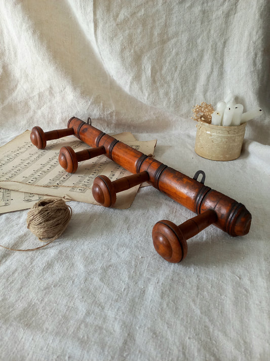 French Antique Faux Bamboo Coat Rack with Four Pegs in rustic setting.
