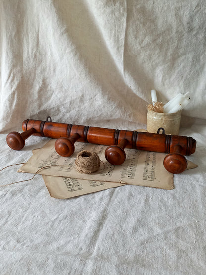 French Antique Faux Bamboo Coat Rack with Four Pegs in rustic setting.
