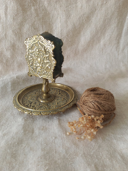 French antique  brass matchbox holder in a decorative setting.