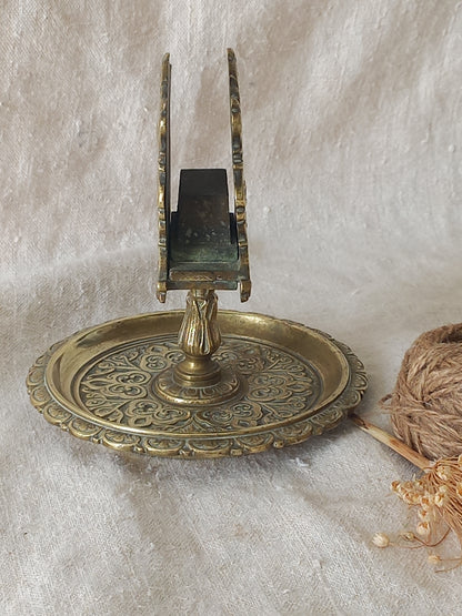 French antique  brass matchbox holder in a decorative setting.