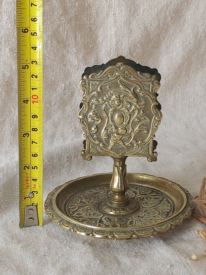 French antique  brass matchbox holder in a decorative setting.