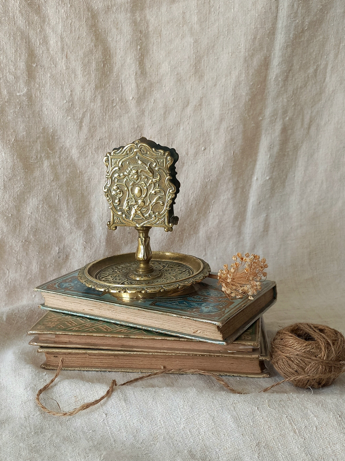 French antique  brass matchbox holder in a decorative setting.