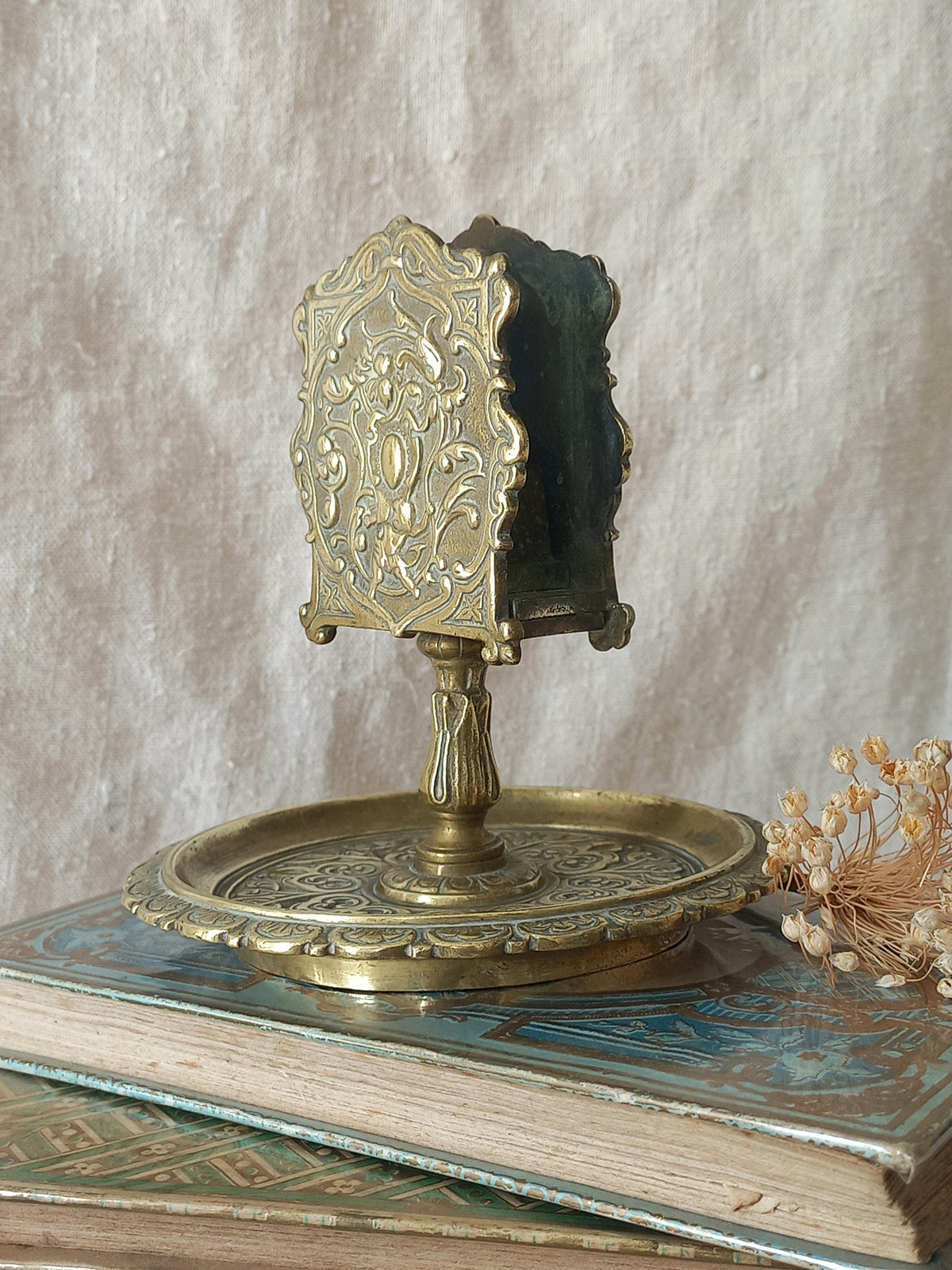 French antique  brass matchbox holder in a decorative setting.