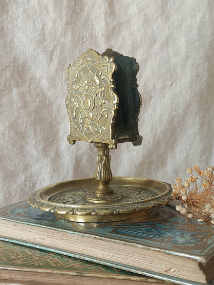 French antique  brass matchbox holder in a decorative setting.