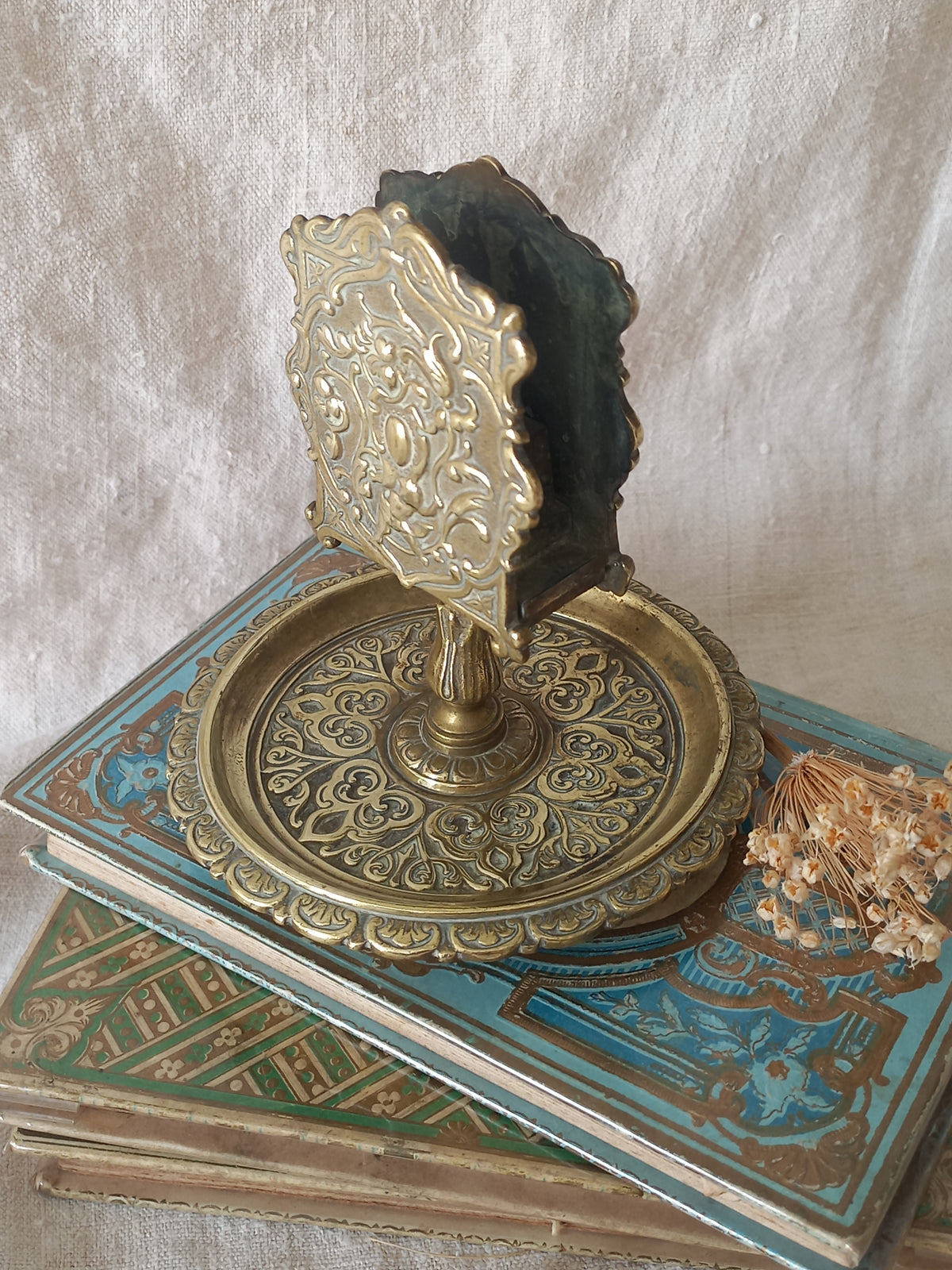 French antique  brass matchbox holder in a decorative setting.