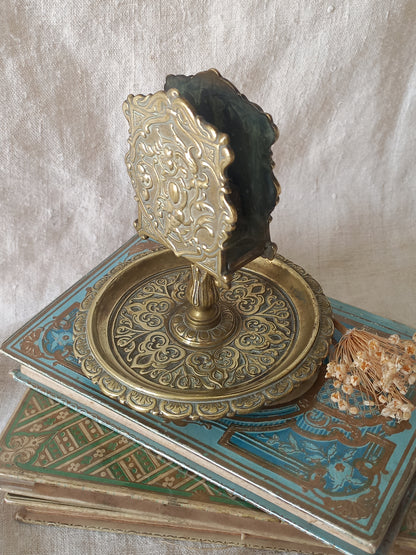 French antique  brass matchbox holder in a decorative setting.