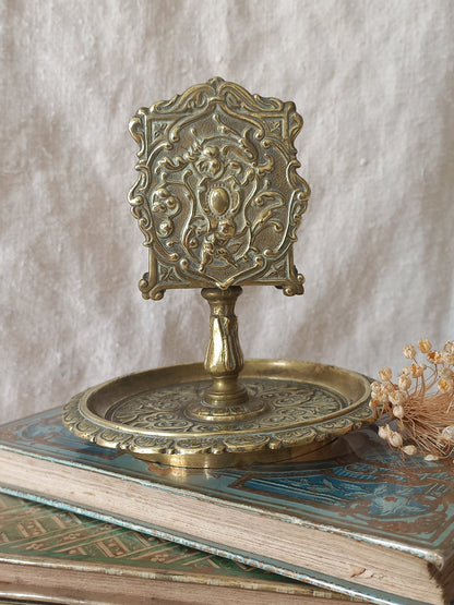 French antique  brass matchbox holder in a decorative setting.