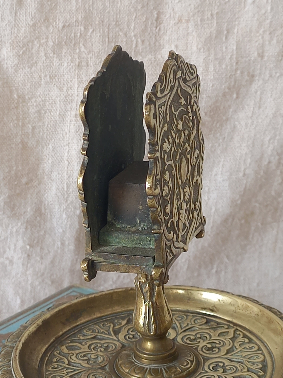 French antique  brass matchbox holder in a decorative setting.