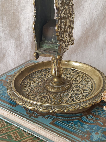 French antique  brass matchbox holder in a decorative setting.
