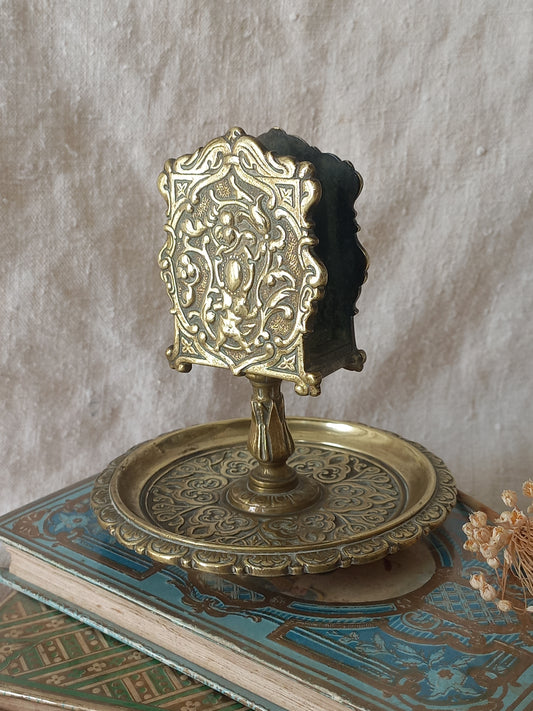 French antique  brass matchbox holder in a decorative setting.