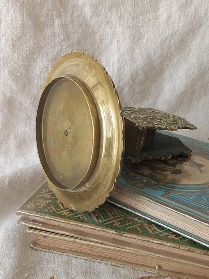 French antique  brass matchbox holder in a decorative setting.