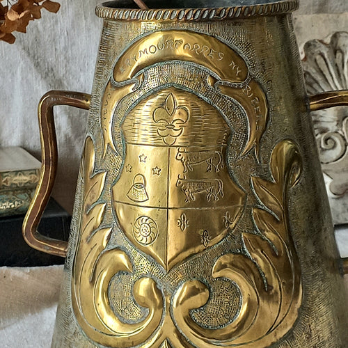 A decorative vintage/antique brass vase with a coat of arms - an unusual piece of brass ware likely a tourist piece inspired by old fountains that were often decorated with a family, commune or regional coat of arms. These days it could have many uses including stand-alone home decor, a decorative vase, or maybe a planter (if considering as a planter the top opening is: 10.7 cm (just over 4'').