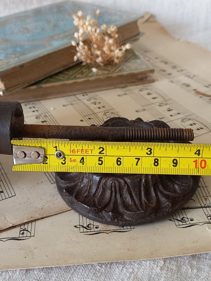 French antique decorative cast iron door pull with tape measure for reference.