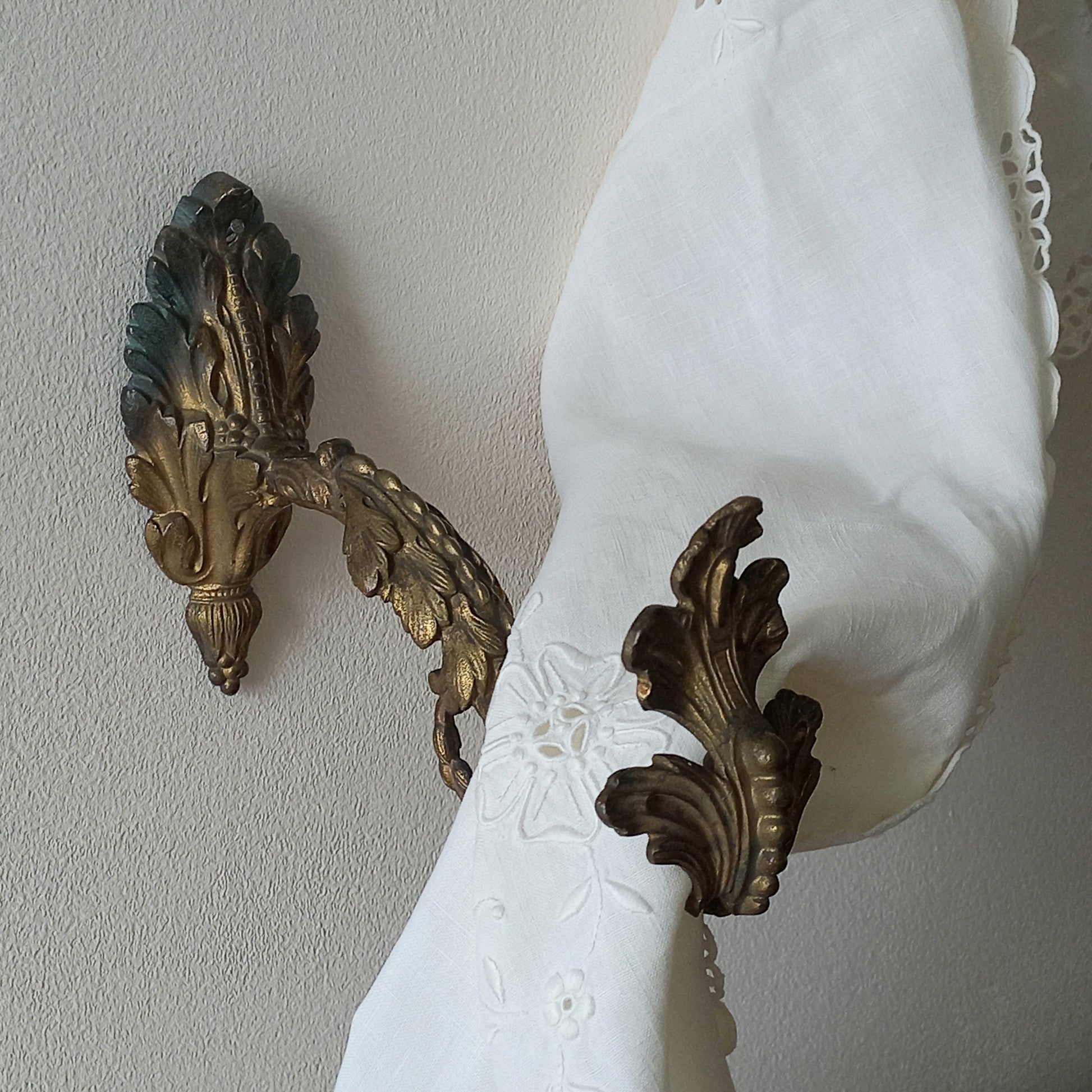 Decorative wall sconces with intricate designs on a plain wall.