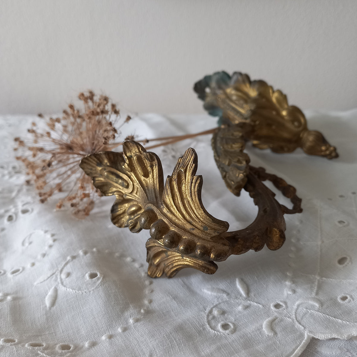 Decorative gold leaf design on a textured white fabric background