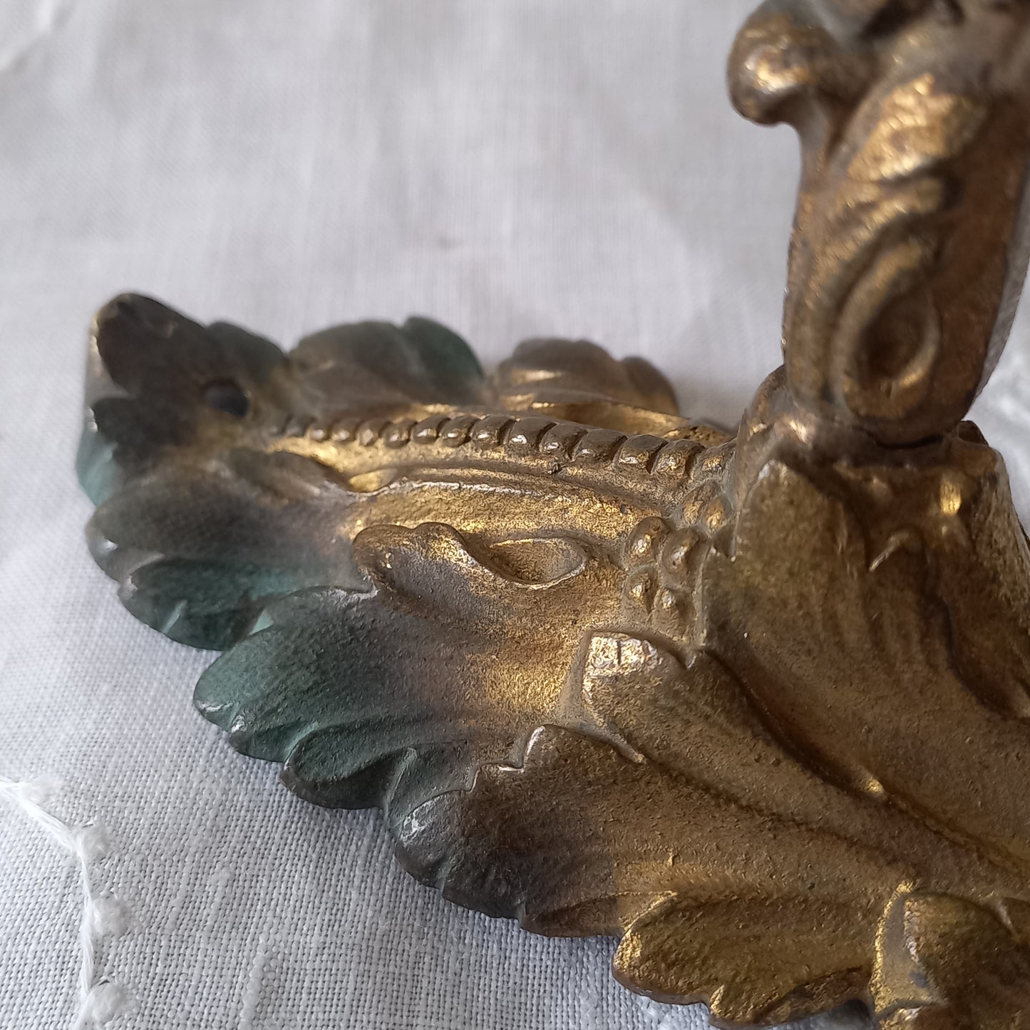 Decorative gold leaf design on a white fabric background