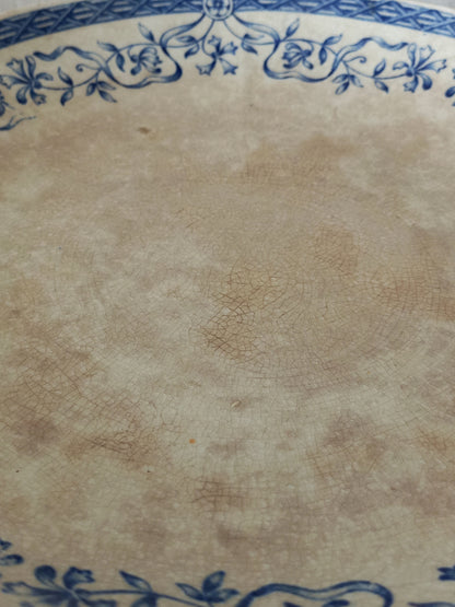 Close-up of a ceramic cake plate with blue floral patterns on a beige background