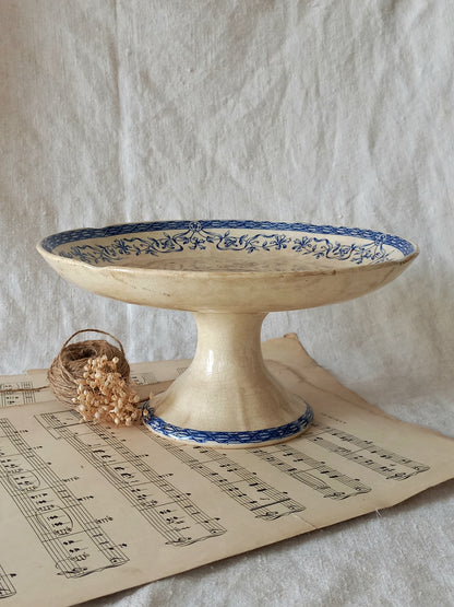 Decorative ceramic pedestal with blue patterns on a sheet of music