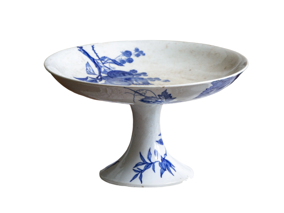 Compotier sur pied en faïence blanche ancienne française, orné d'un motif de libellule bleue et de fleurs. 