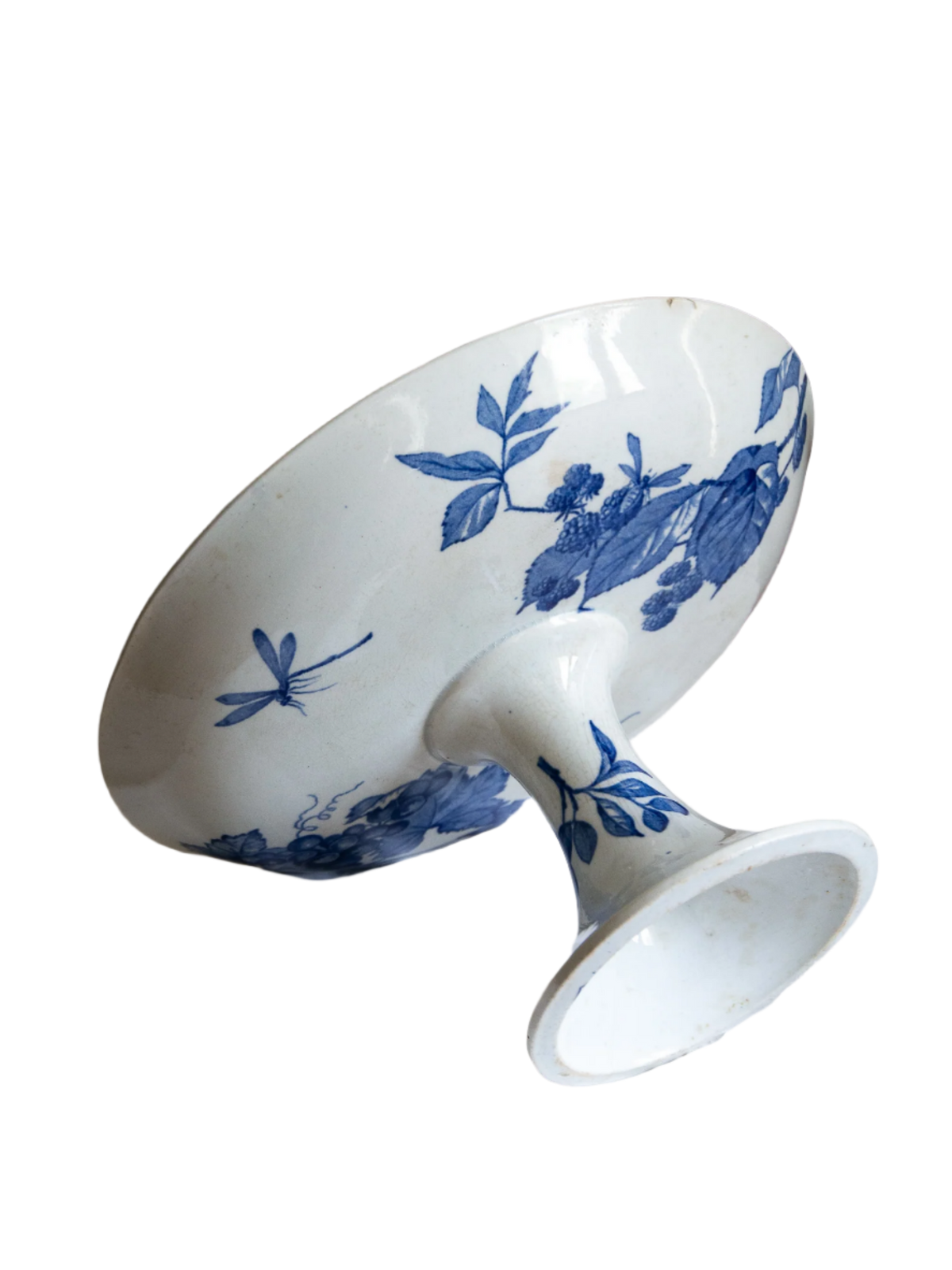 Compotier sur pied en faïence blanche ancienne française, orné d'un motif de libellule bleue et de fleurs. 