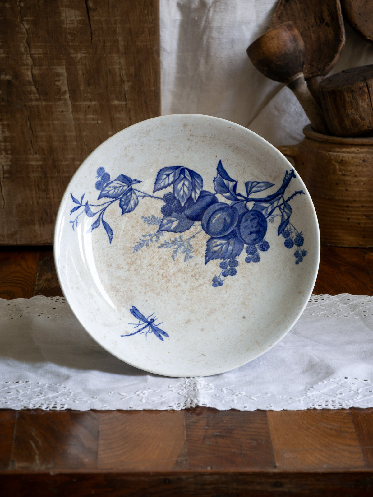 Compotier sur pied en faïence blanche ancienne française, orné d'un motif de libellule bleue et de fleurs. 