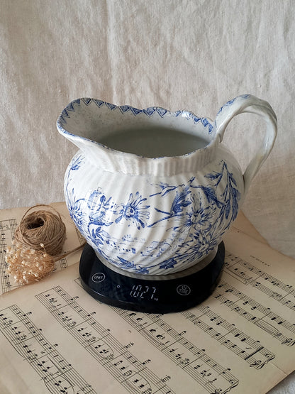 Blue and white ceramic pitcher on a digital scale with music sheet background