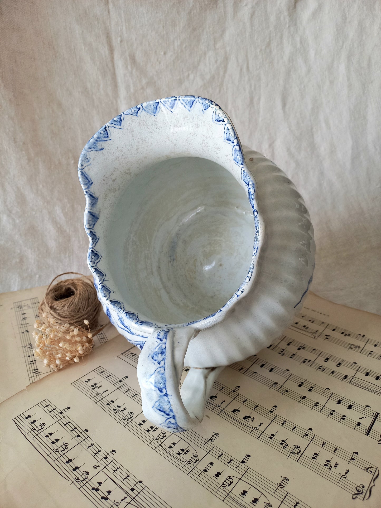 Ceramic pitcher with blue rim on a sheet of music