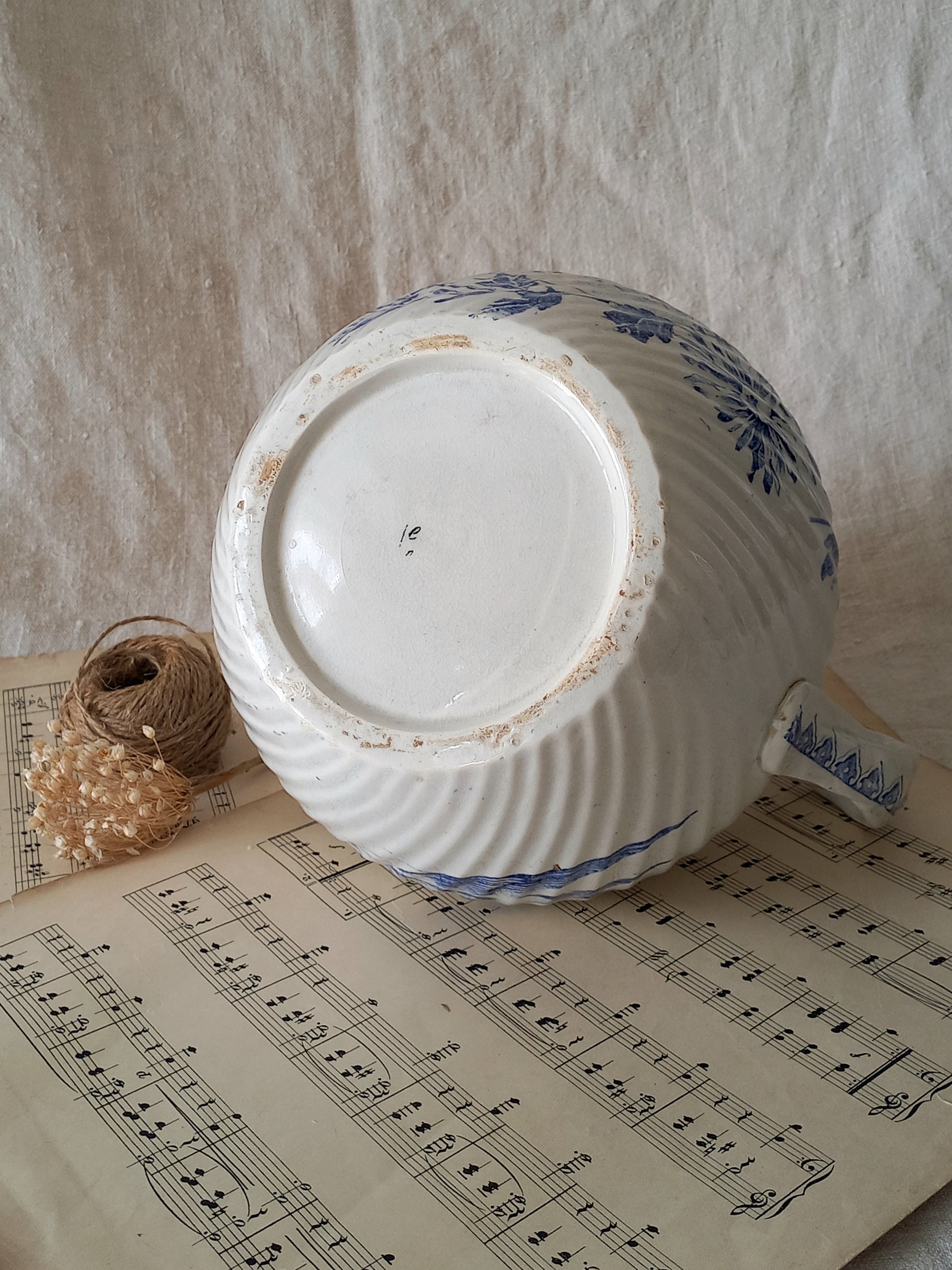 Ceramic jug with blue patterns on a sheet of music
