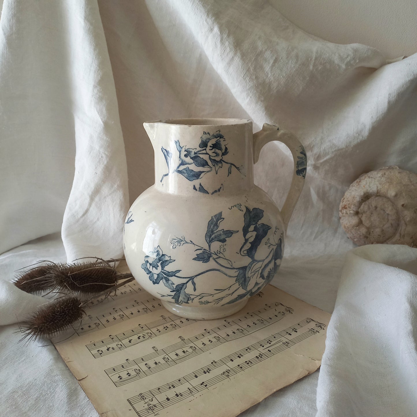 A large and beautiful French antique ironstone jug in a lovely aged white with blue floral transfer pattern. This wonderful piece of ironstone history has a super patina of age that gives it that look we all admire.