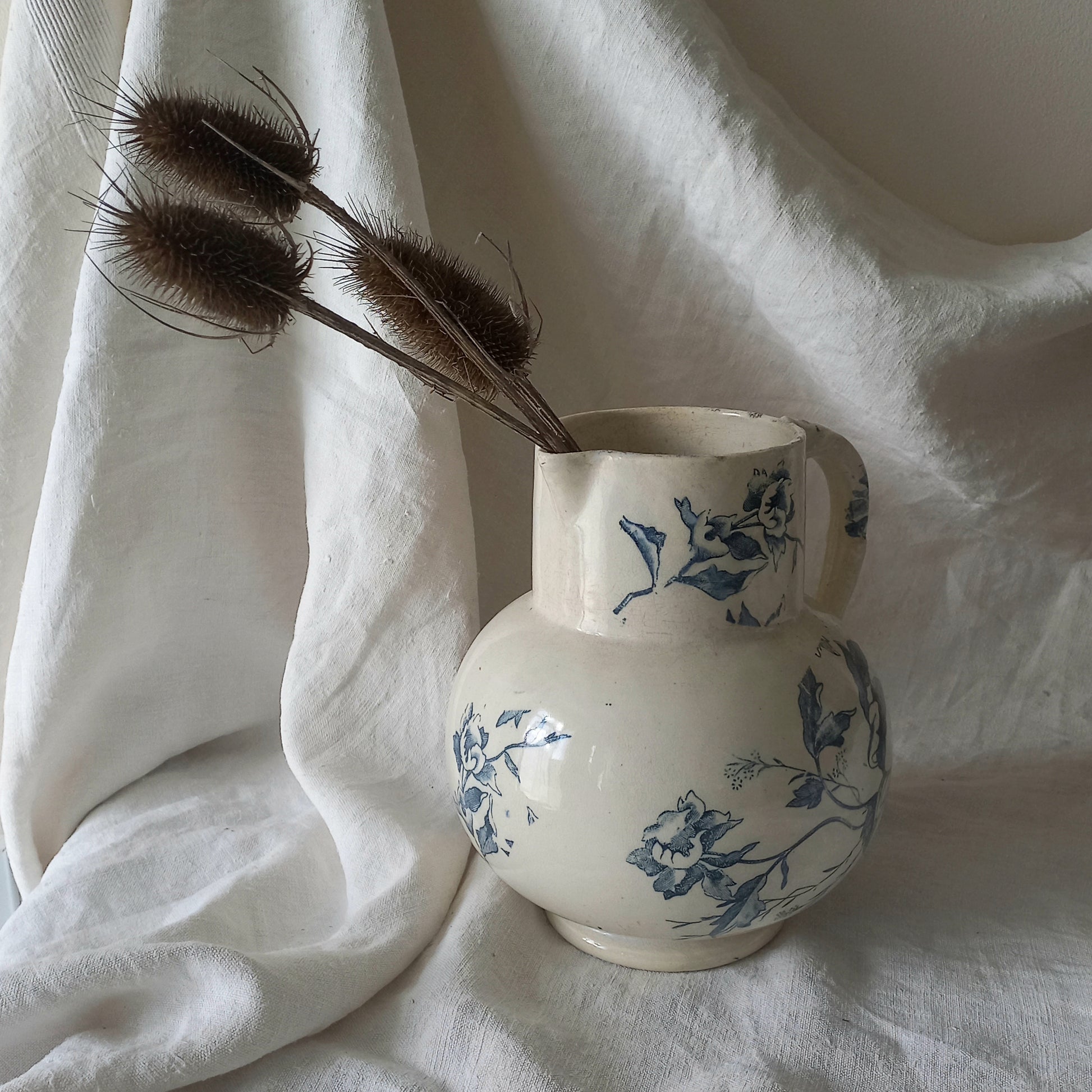 A large and beautiful French antique ironstone jug in a lovely aged white with blue floral transfer pattern. This wonderful piece of ironstone history has a super patina of age that gives it that look we all admire.