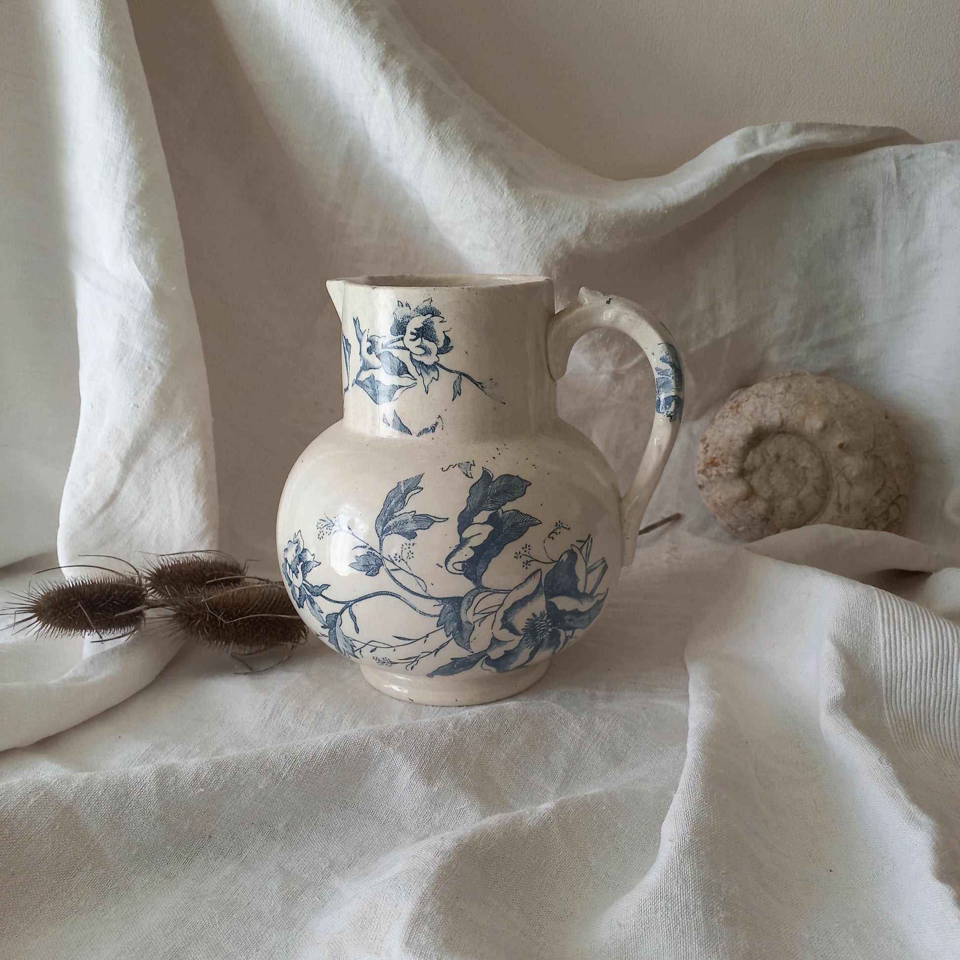 A large and beautiful French antique ironstone jug in a lovely aged white with blue floral transfer pattern. This wonderful piece of ironstone history has a super patina of age that gives it that look we all admire.