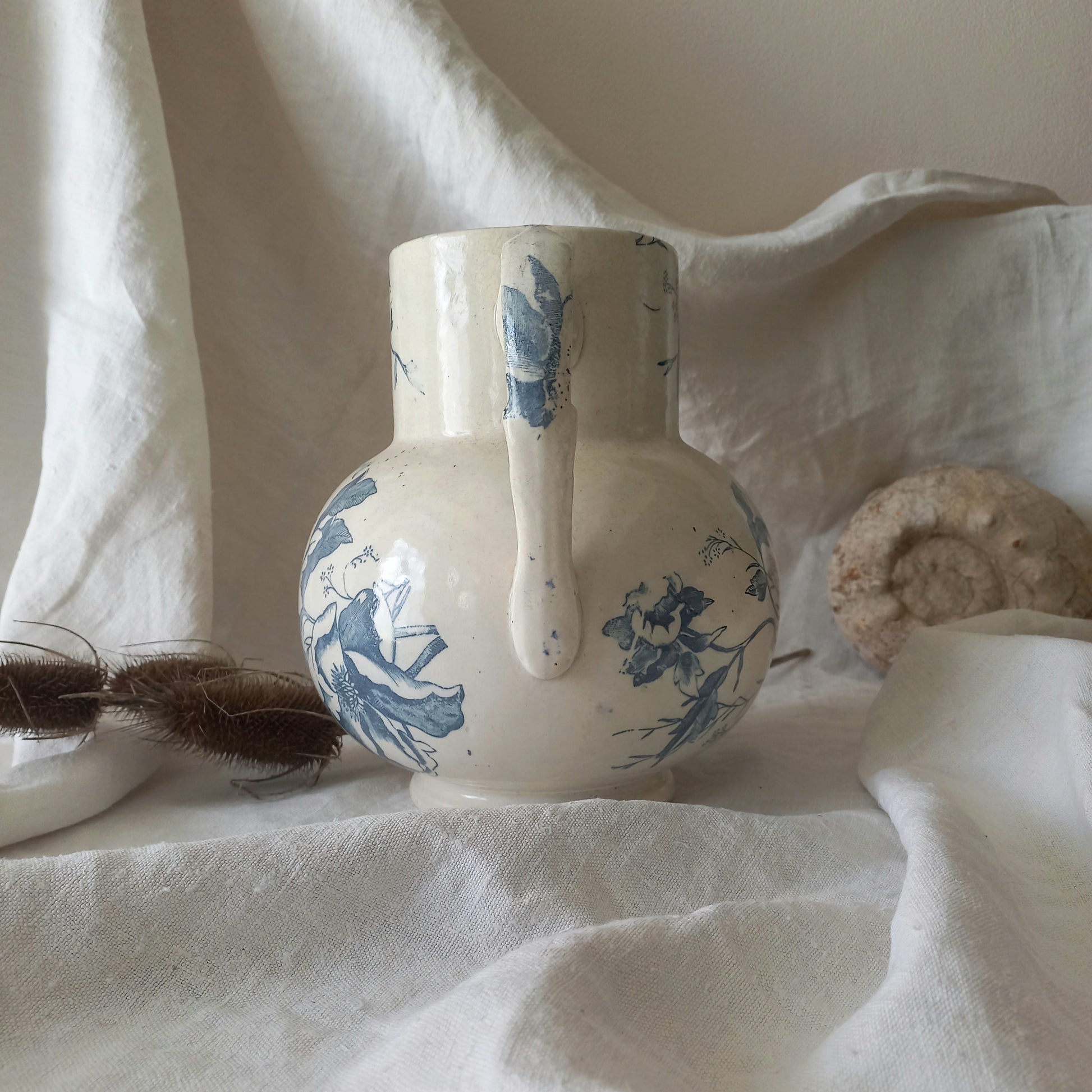 A large and beautiful French antique ironstone jug in a lovely aged white with blue floral transfer pattern. This wonderful piece of ironstone history has a super patina of age that gives it that look we all admire.